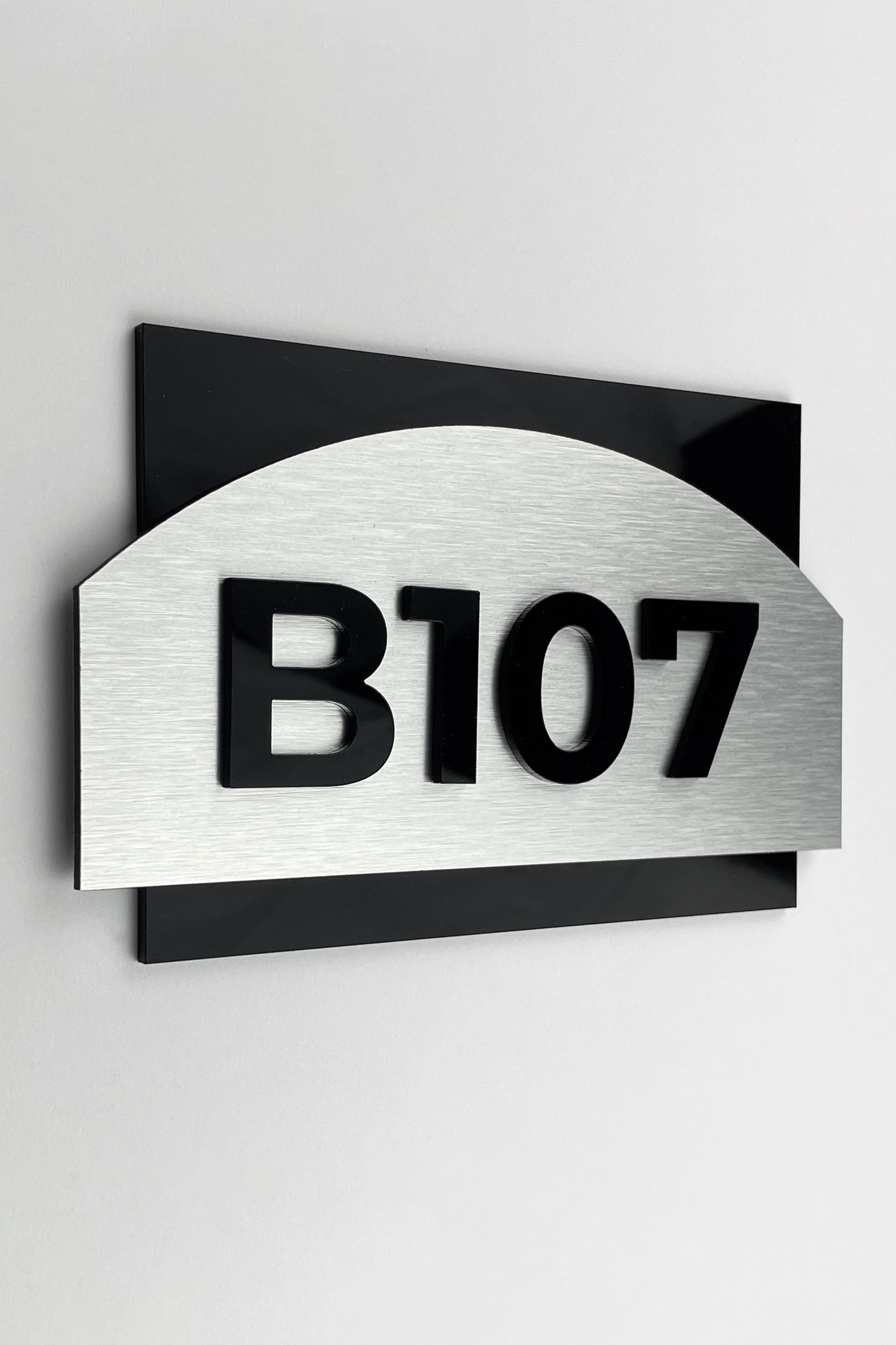 ALUMADESIGNCO Flow Design modern apartment door number sign with brushed silver plaque and black acrylic glass numbers, elegant signage for apartments and interiors