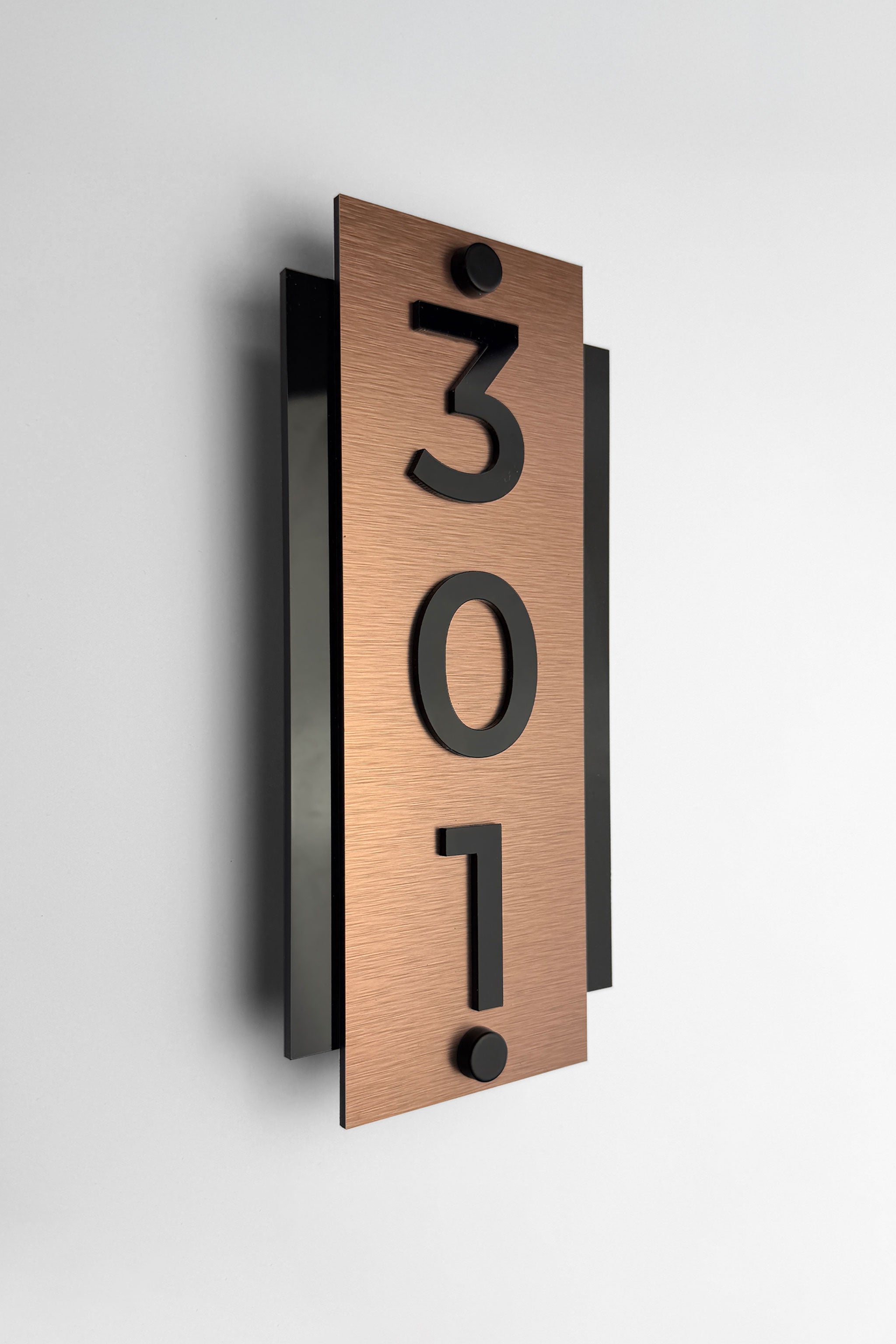 Brushed bronze standoff hotel room number sign Vertical Design by ALUMADESIGNCO featuring metal plaque and acrylic numbers, modern hotel door signage for corridors and apartments