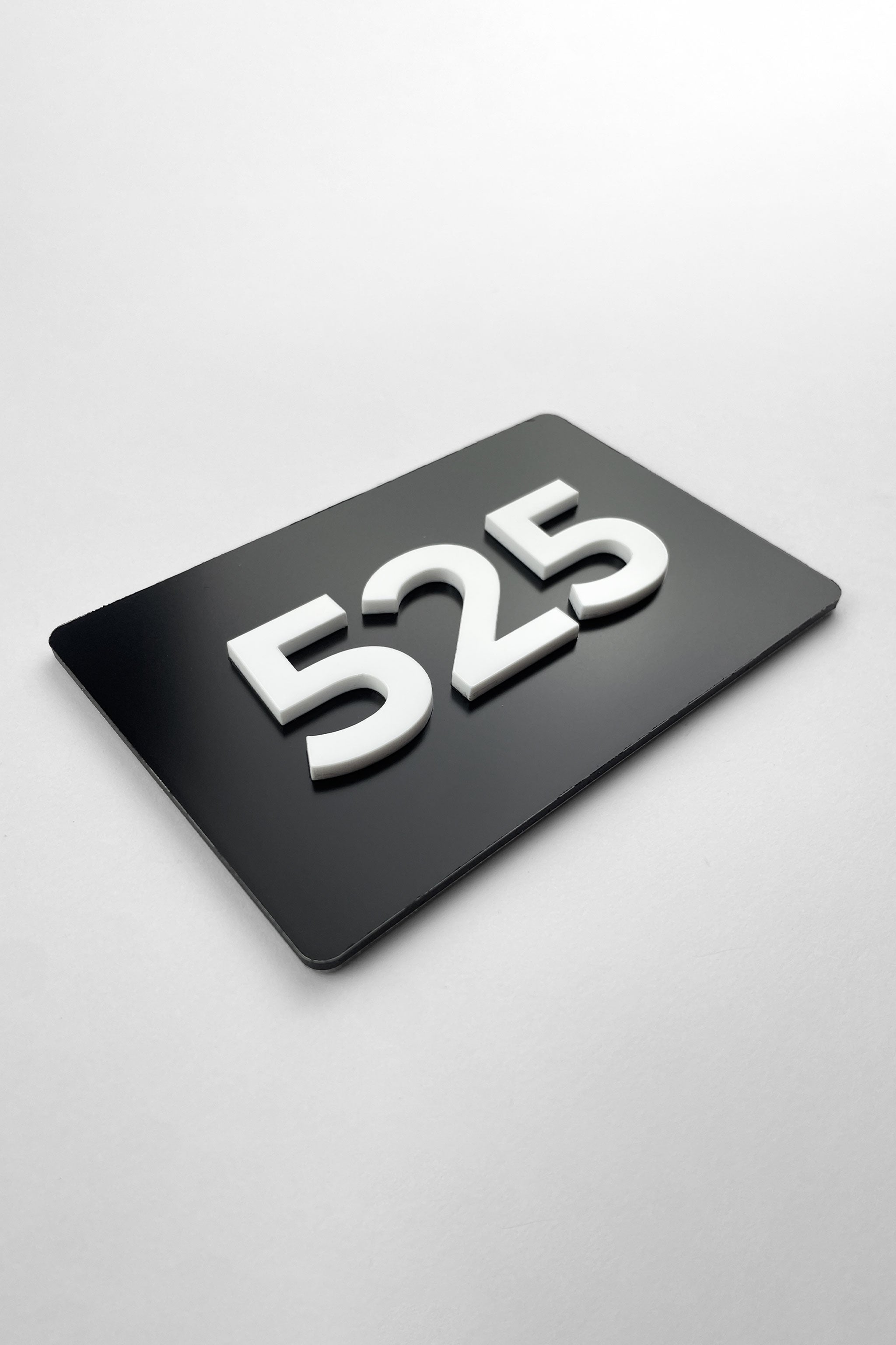 Custom black metal and white acrylic room number sign by ALUMADESIGNCO, modern door plaque for hotel rooms, apartment doors, and contemporary interiors