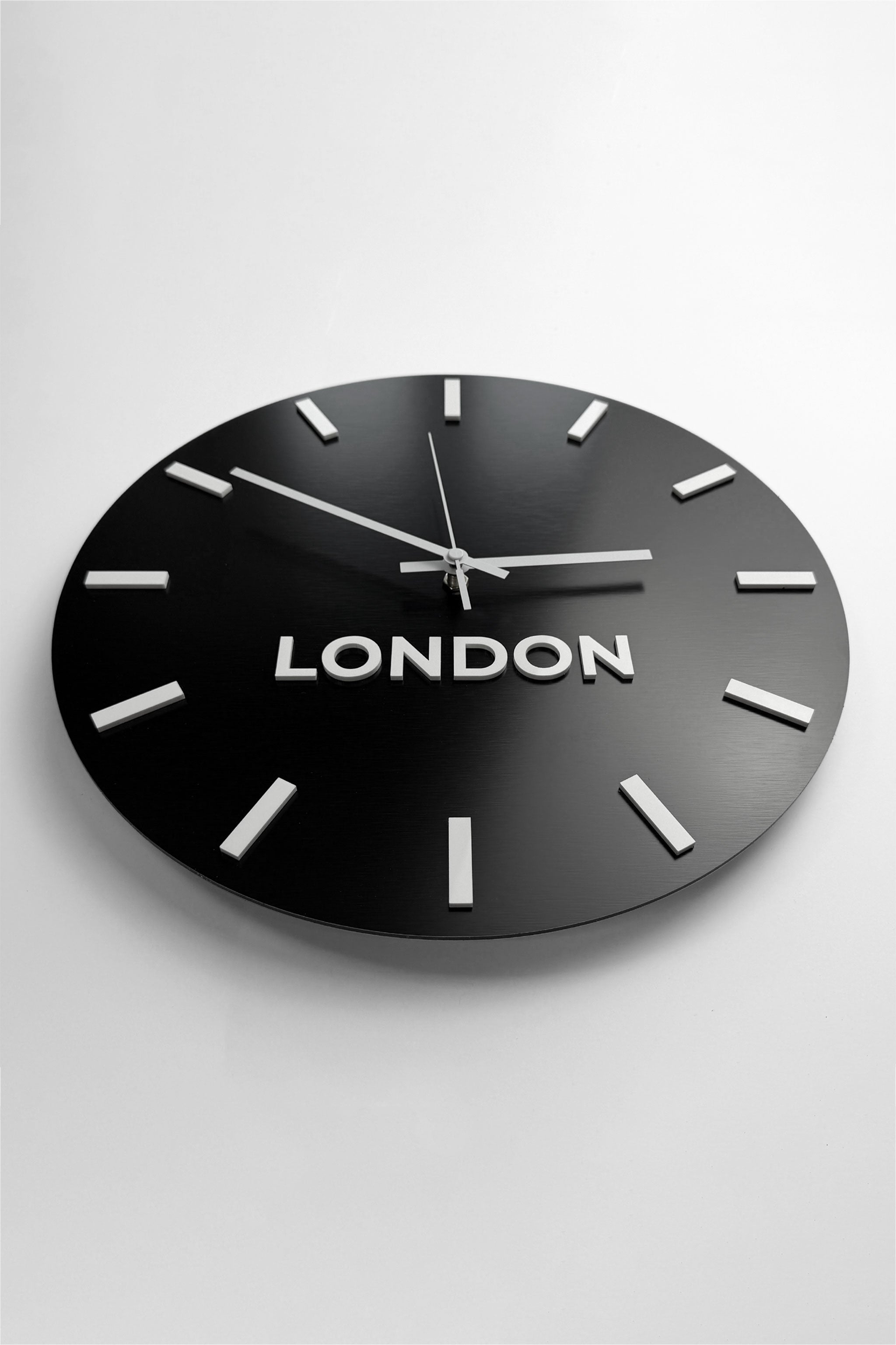 Personalized world time zone wall clock by ALUMADESIGNCO featuring brushed black finish and white acrylic glass city name plaques, elegant décor for offices, reception areas, and modern spaces