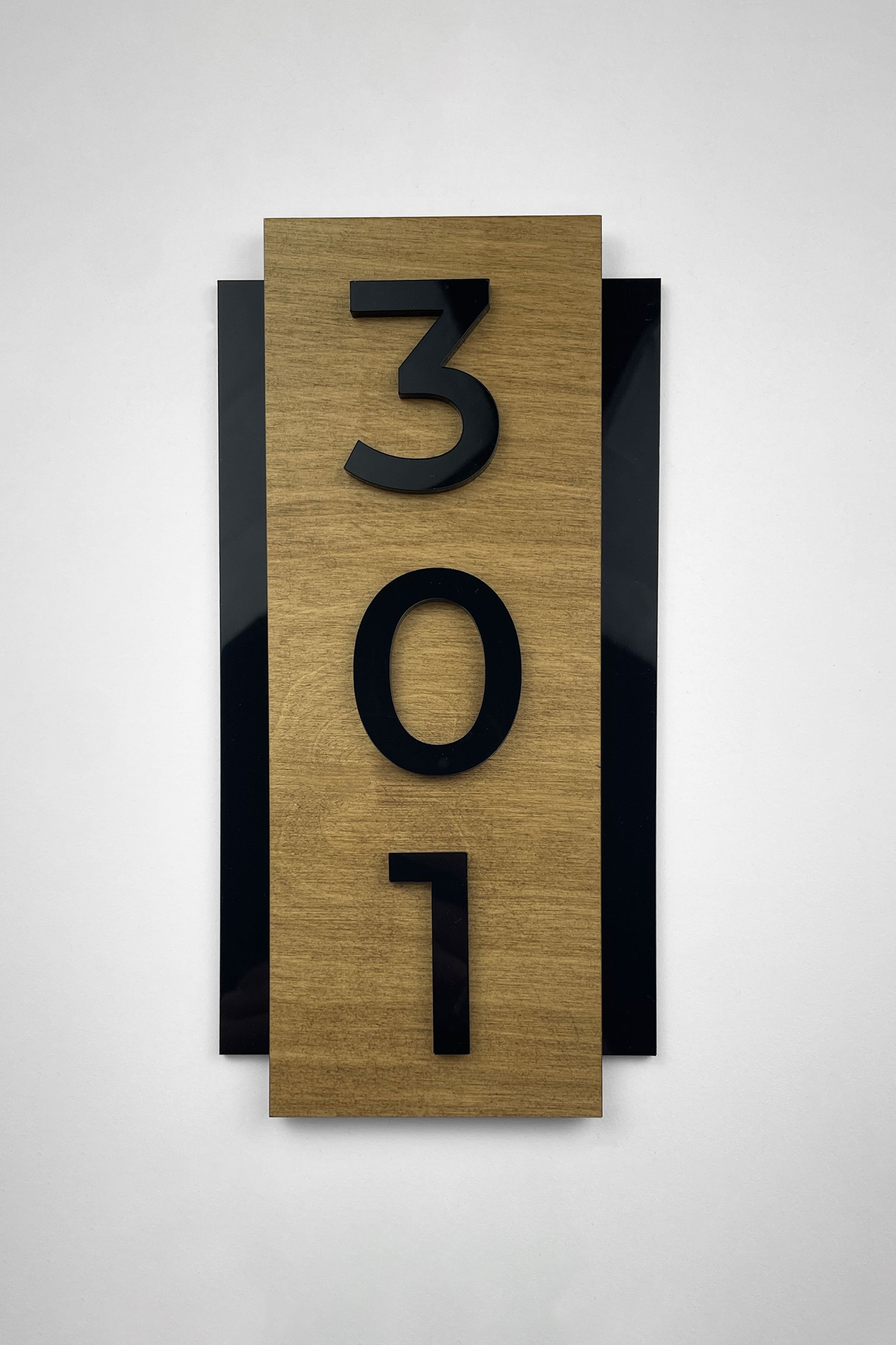 Vertical hotel room number sign by ALUMADESIGNCO crafted from birch plywood with raised black acrylic numbers, modern wood and acrylic door plaque for hotels, boutique apartments, and office interiors