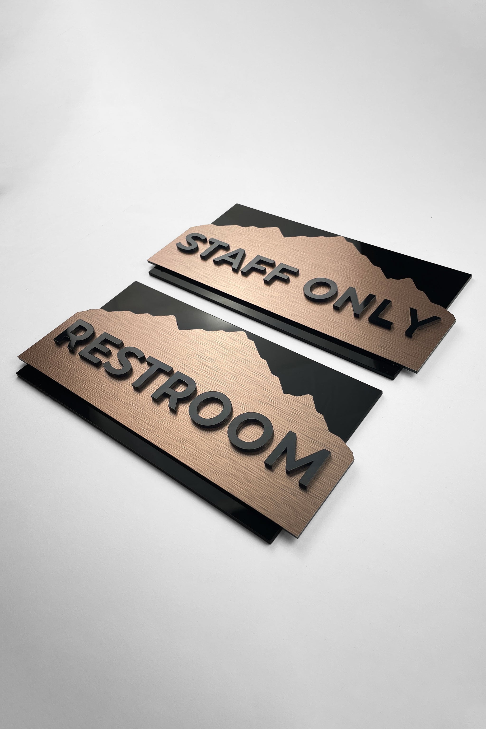 Modern custom interior door sign by ALUMADESIGNCO combining brushed bronze metal panel and black acrylic lettering, stylish signage for contemporary interior spaces