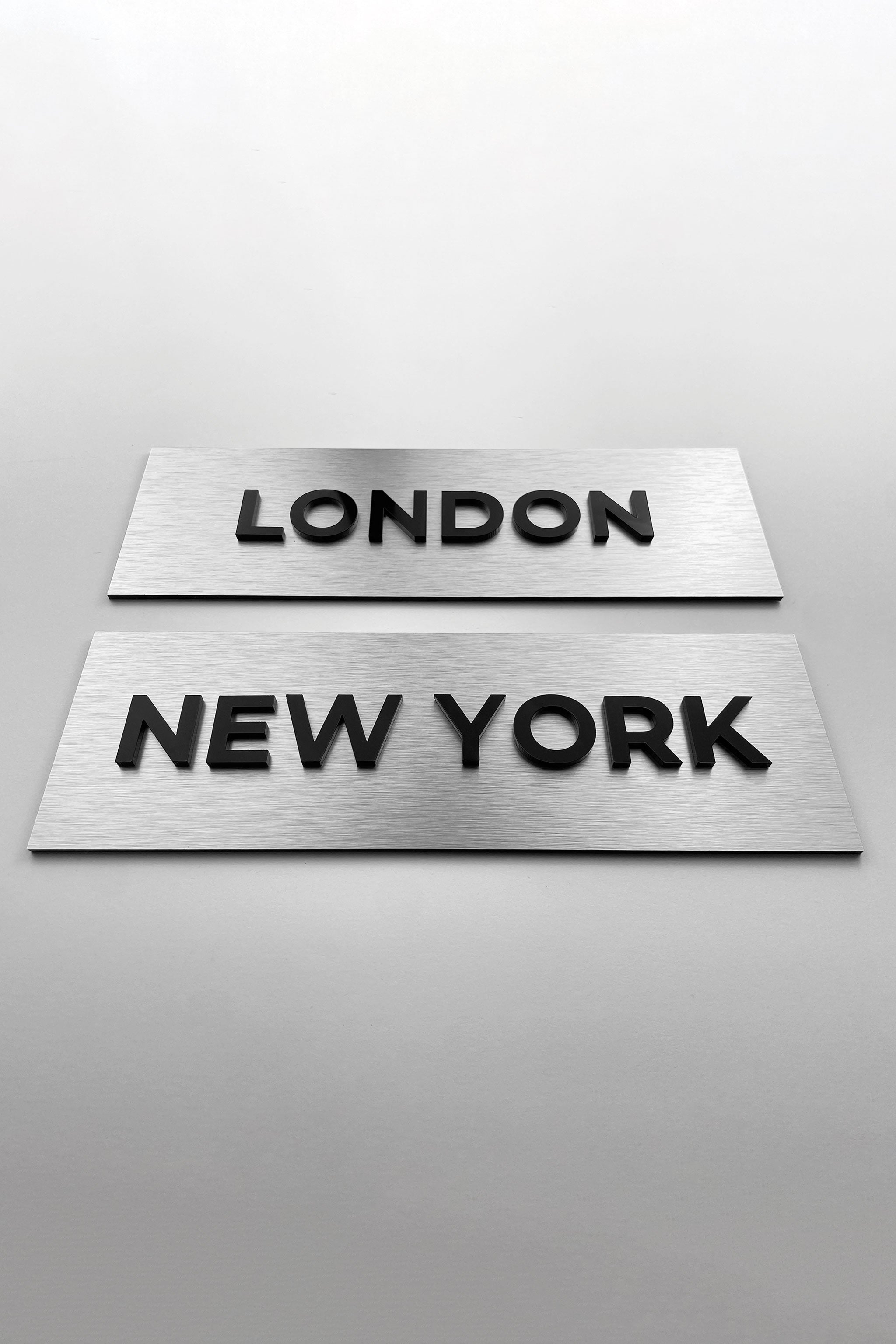 Custom brushed silver door sign with black acrylic lettering by ALUMADESIGNCO, elegant plaque for offices, meeting rooms, and contemporary interiors