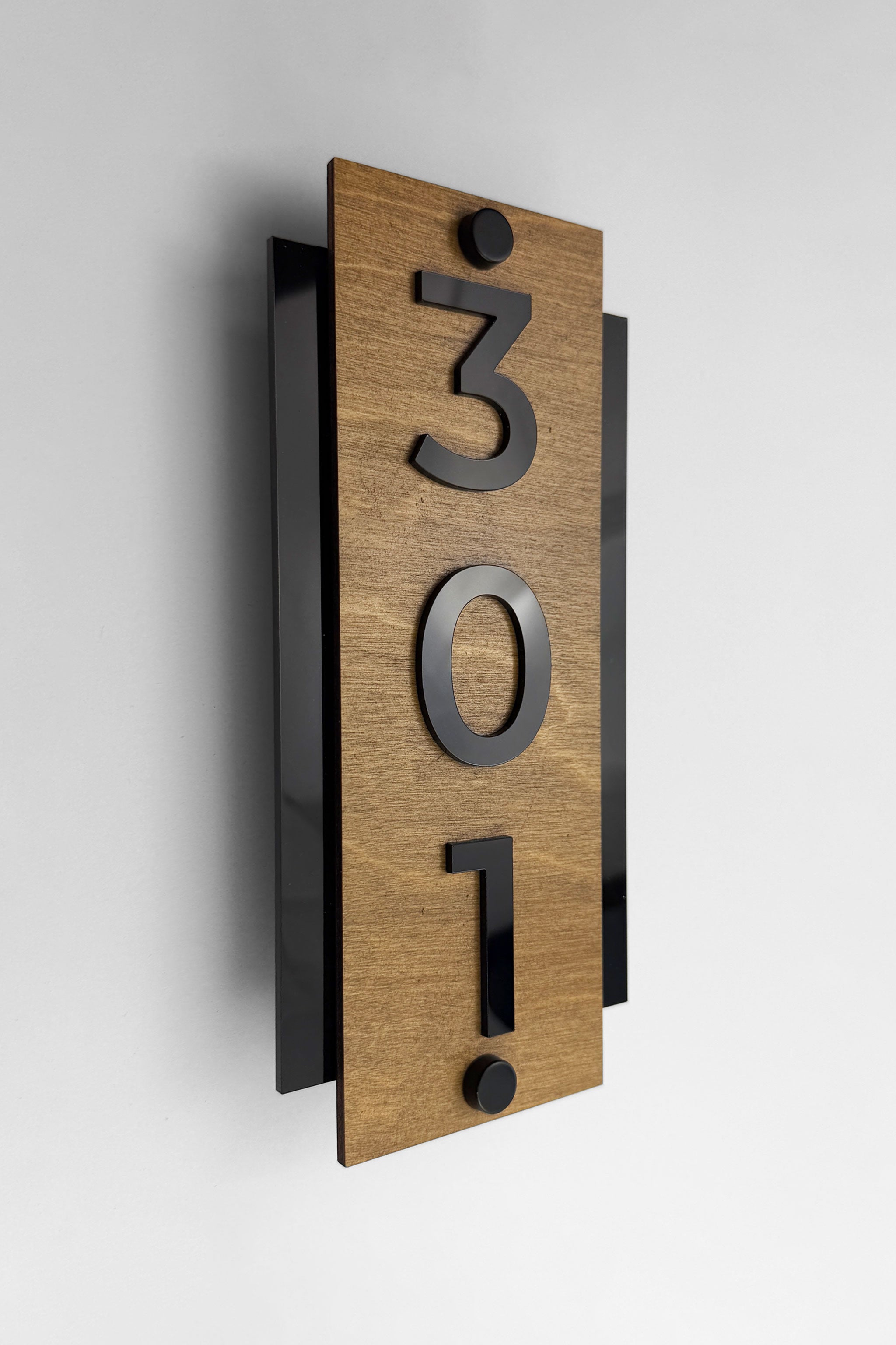 Standoff vertical hotel room number sign by ALUMADESIGNCO crafted from birch plywood with raised black acrylic numbers, modern wood and acrylic signage with steel standoff mounting for hotels and offices