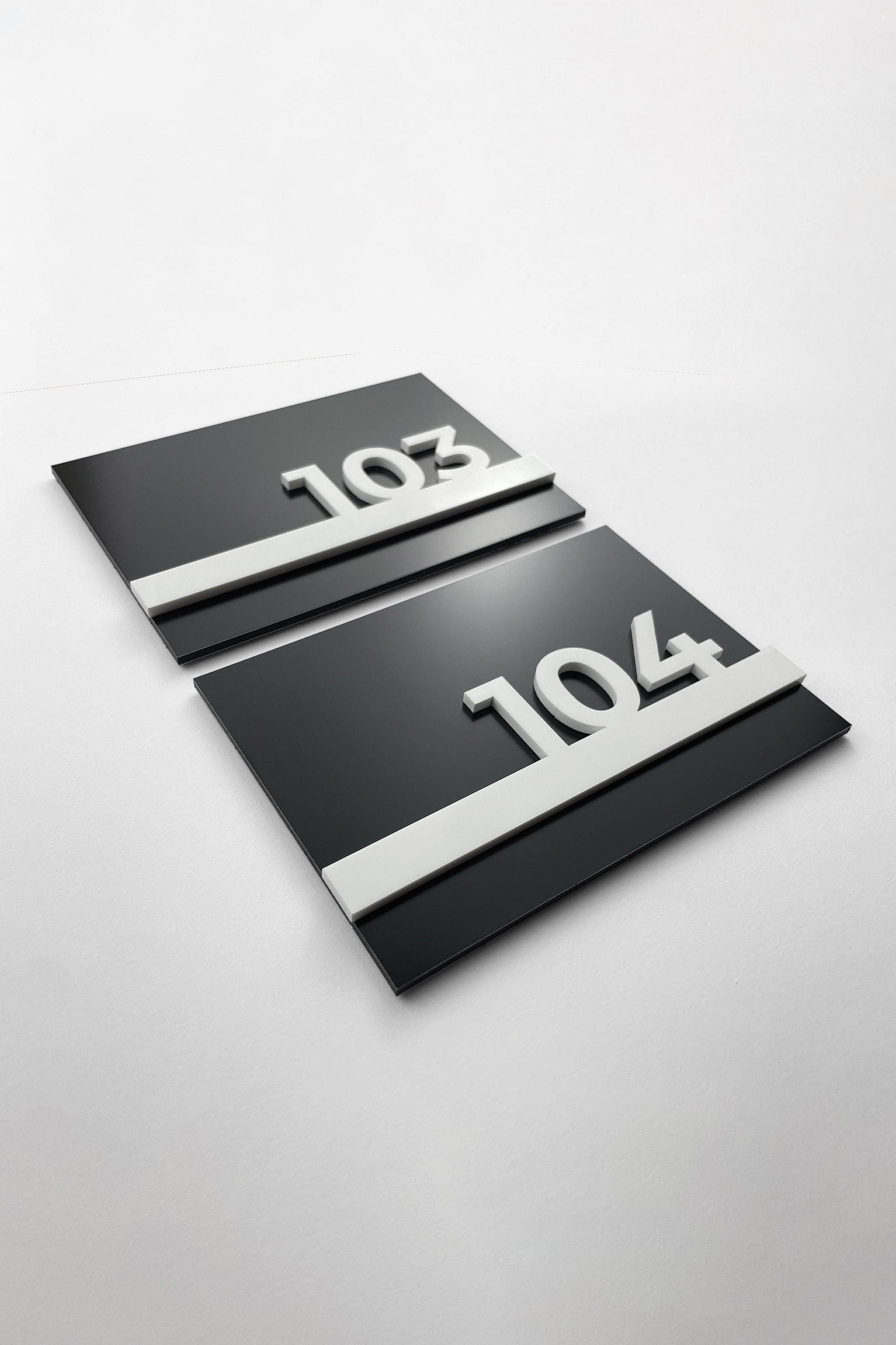 Black metal and white acrylic hotel room number sign by ALUMADESIGNCO, modern door plaque for hotel corridors and contemporary interiors