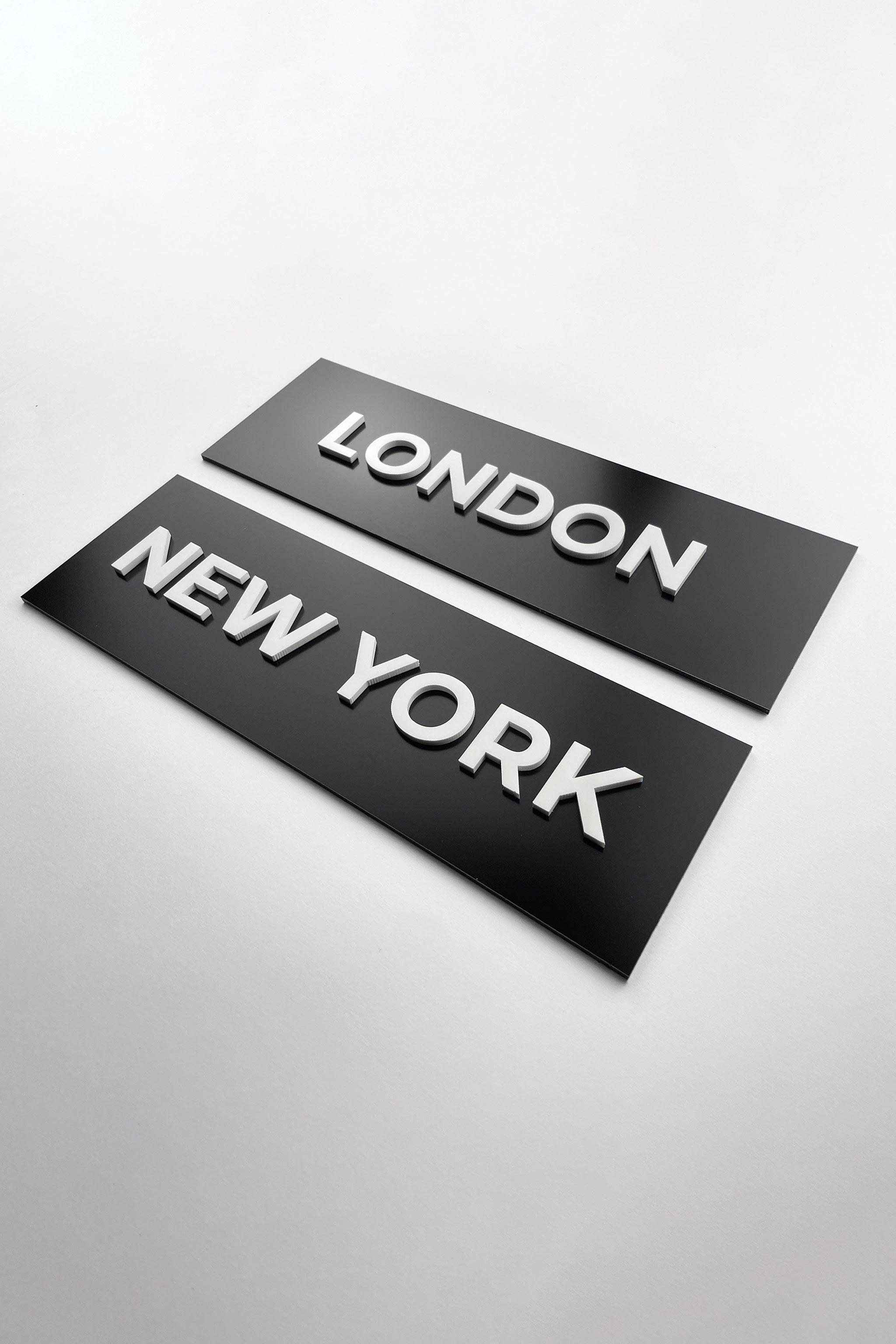 Premium black door name plate by ALUMADESIGNCO featuring white acrylic lettering, modern custom signage for offices, hotel interiors, and conference rooms