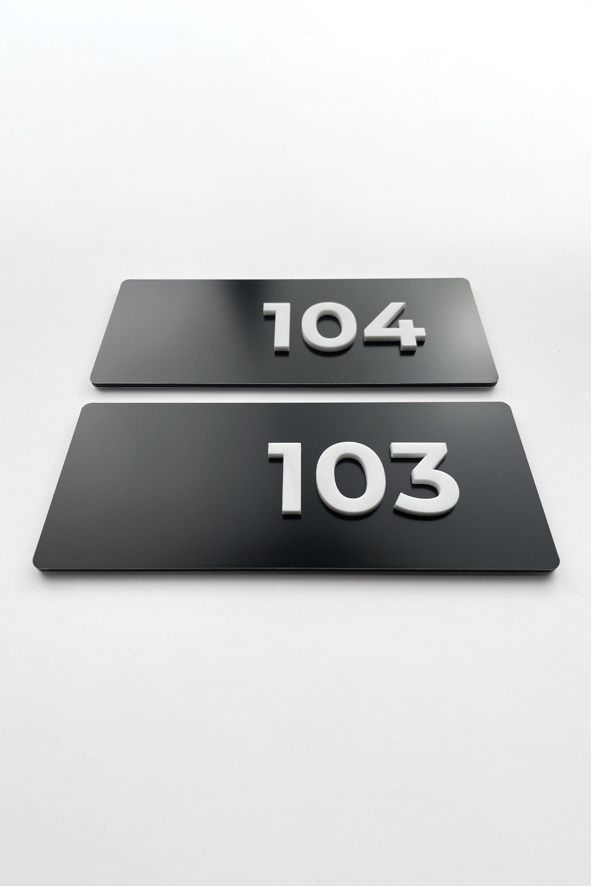 Custom black metal and white acrylic suite number sign by ALUMADESIGNCO, modern door plaque for hotel suites and contemporary interiors