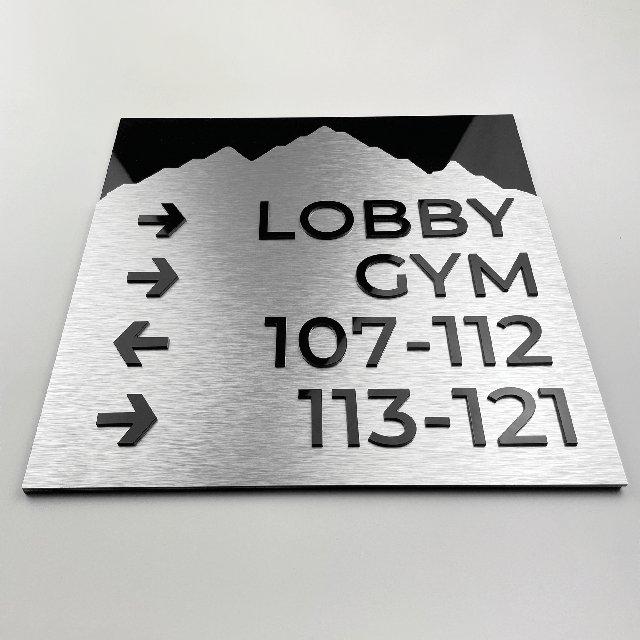 Aluminium plate directional sign for restroom facilities with standard iconographyOutdoor installation of aluminium wayfinding sign with standard design guiding to parking