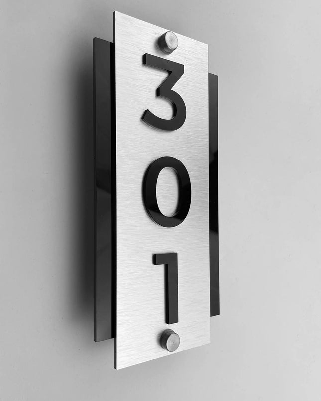 Vertical hotel room number sign by ALUMADESIGNCO with silver metal plaque and raised acrylic numbers, modern standoff door signage for hotel corridors and apartments