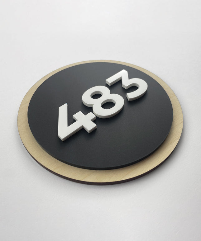 Round wood and acrylic hotel room number sign by ALUMADESIGNCO featuring birch plywood base with raised black acrylic numbers, modern Scandinavian door plaque for hotel corridors and apartments