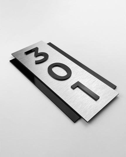 Vertical brushed silver room number sign by ALUMADESIGNCO featuring metal plaque and acrylic numbers, modern wall door signage for hotel corridors and apartment buildings