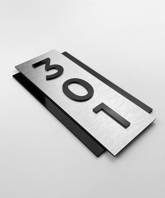 Vertical brushed silver room number sign by ALUMADESIGNCO featuring metal plaque and acrylic numbers, modern wall door signage for hotel corridors and apartment buildings