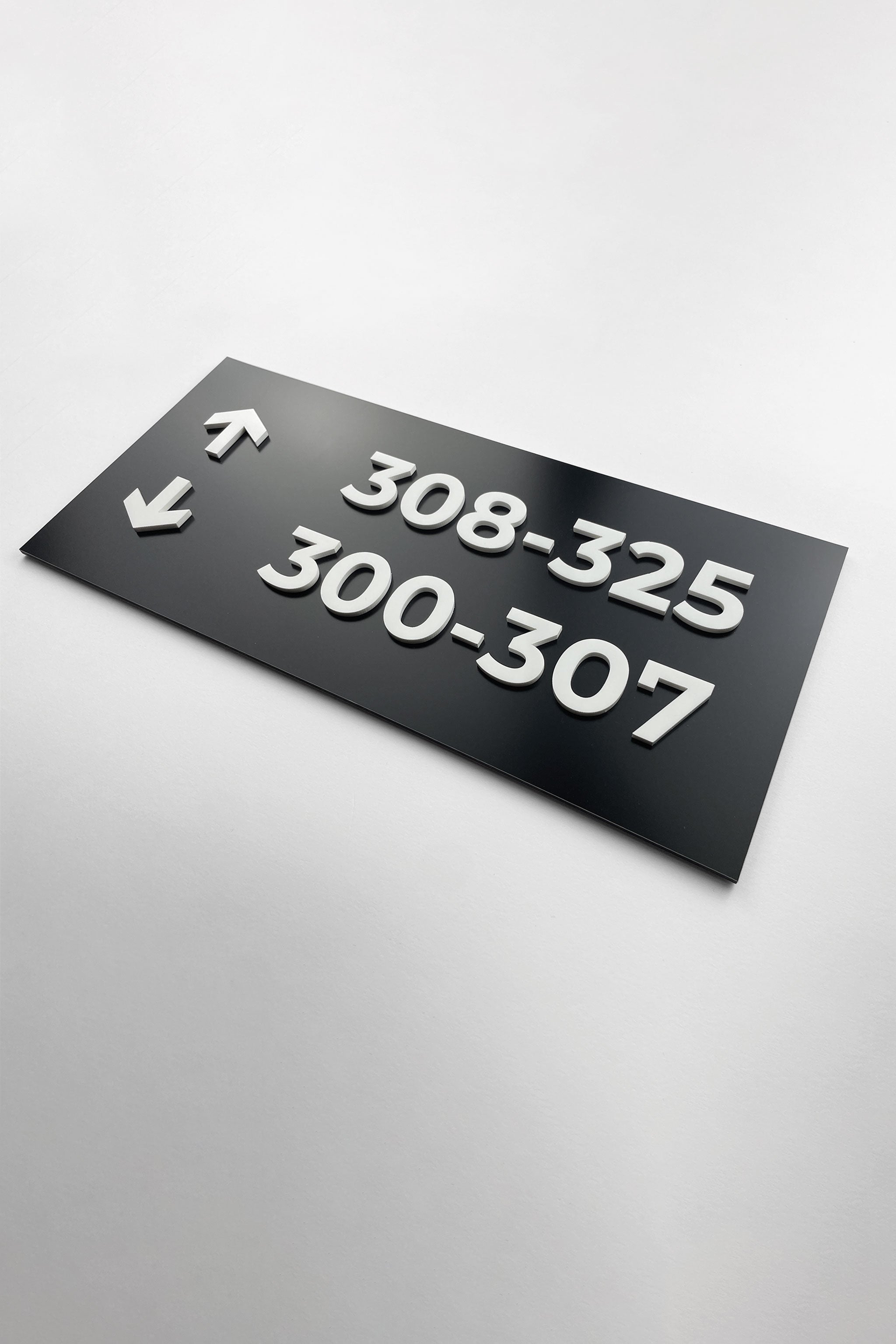 Black and white wayfinding sign wall plaque in Modern Design by ALUMADESIGNCO, stylish directional signage for offices, hotels, corridors, and modern interior spaces