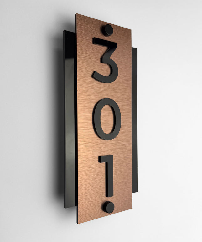 Brushed bronze standoff hotel room number sign Vertical Design by ALUMADESIGNCO featuring metal plaque and acrylic numbers, modern hotel door signage for corridors and apartments