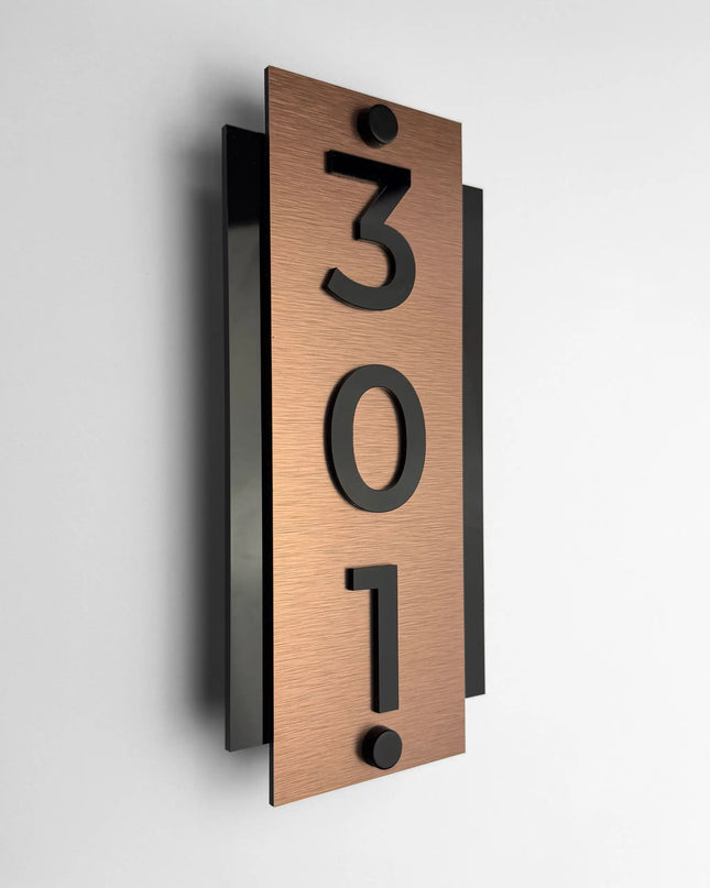 Brushed bronze standoff hotel room number sign Vertical Design by ALUMADESIGNCO featuring metal plaque and acrylic numbers, modern hotel door signage for corridors and apartments