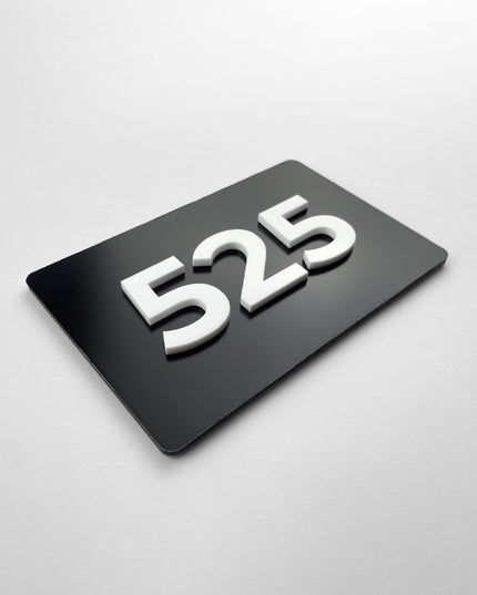 Custom black metal and white acrylic room number sign by ALUMADESIGNCO, modern door plaque for hotel rooms, apartment doors, and contemporary interiors