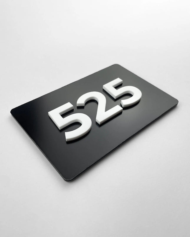 Custom black metal and white acrylic room number sign by ALUMADESIGNCO, modern door plaque for hotel rooms, apartment doors, and contemporary interiors