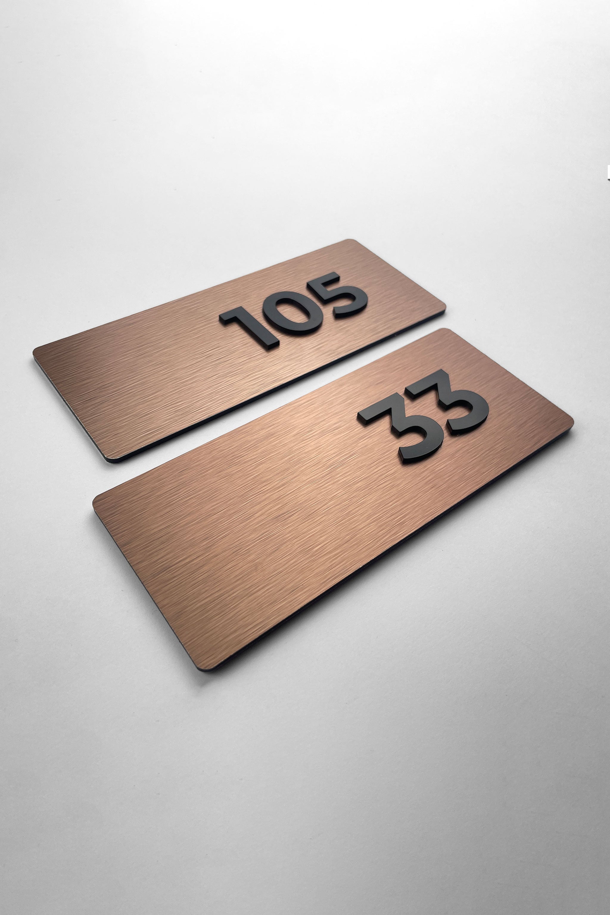 Brushed bronze apartment door number sign Classic Design by ALUMADESIGNCO featuring metal plaque and acrylic numbers, elegant signage for apartment interiors and hotel corridors