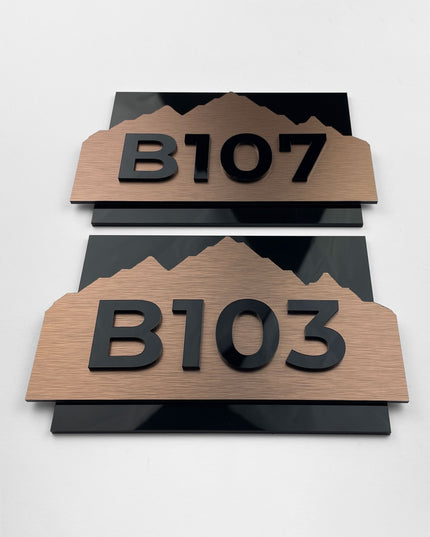 Modern brushed bronze room number sign Alpine Design by ALUMADESIGNCO featuring metal plaque and acrylic numbers, elegant door signage for hotel rooms and apartment interiors