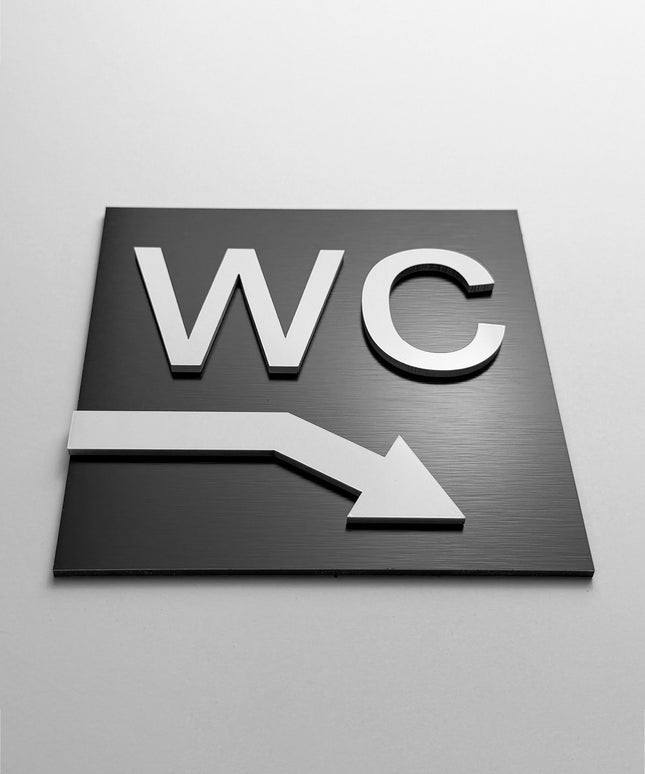 ALUMADESIGNCO WC directional sign with downstairs arrow and minimalist design, premium bathroom wayfinding signage for offices, hospitality spaces, and commercial buildings
