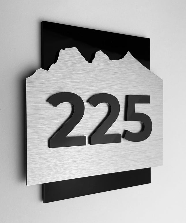 Hotel room number sign Alpine Design by ALUMADESIGNCO featuring brushed silver metal panel and black acrylic numbers, modern door plaque for hotel corridors and apartment interiors