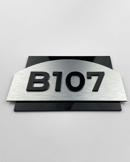 Modern brushed silver and black acrylic glass apartment door number sign Flow Design by ALUMADESIGNCO, premium door plaque for contemporary apartment interiors