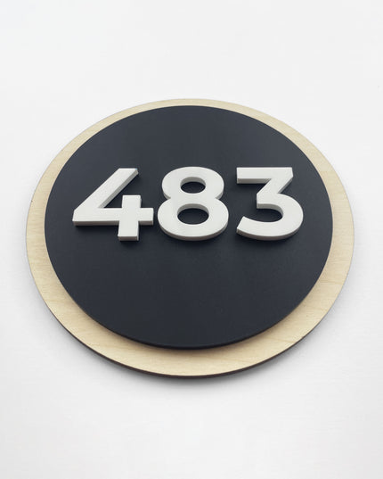 Premium round hotel door number sign by ALUMADESIGNCO featuring birch wood base and black acrylic 3D numbers, modern door signage for hotels, apartments, and offices
