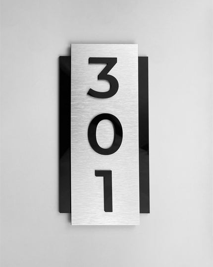 Modern vertical room number sign by ALUMADESIGNCO combining brushed silver aluminum panel and acrylic numbers, elegant wall signage for hotel rooms and apartment doors