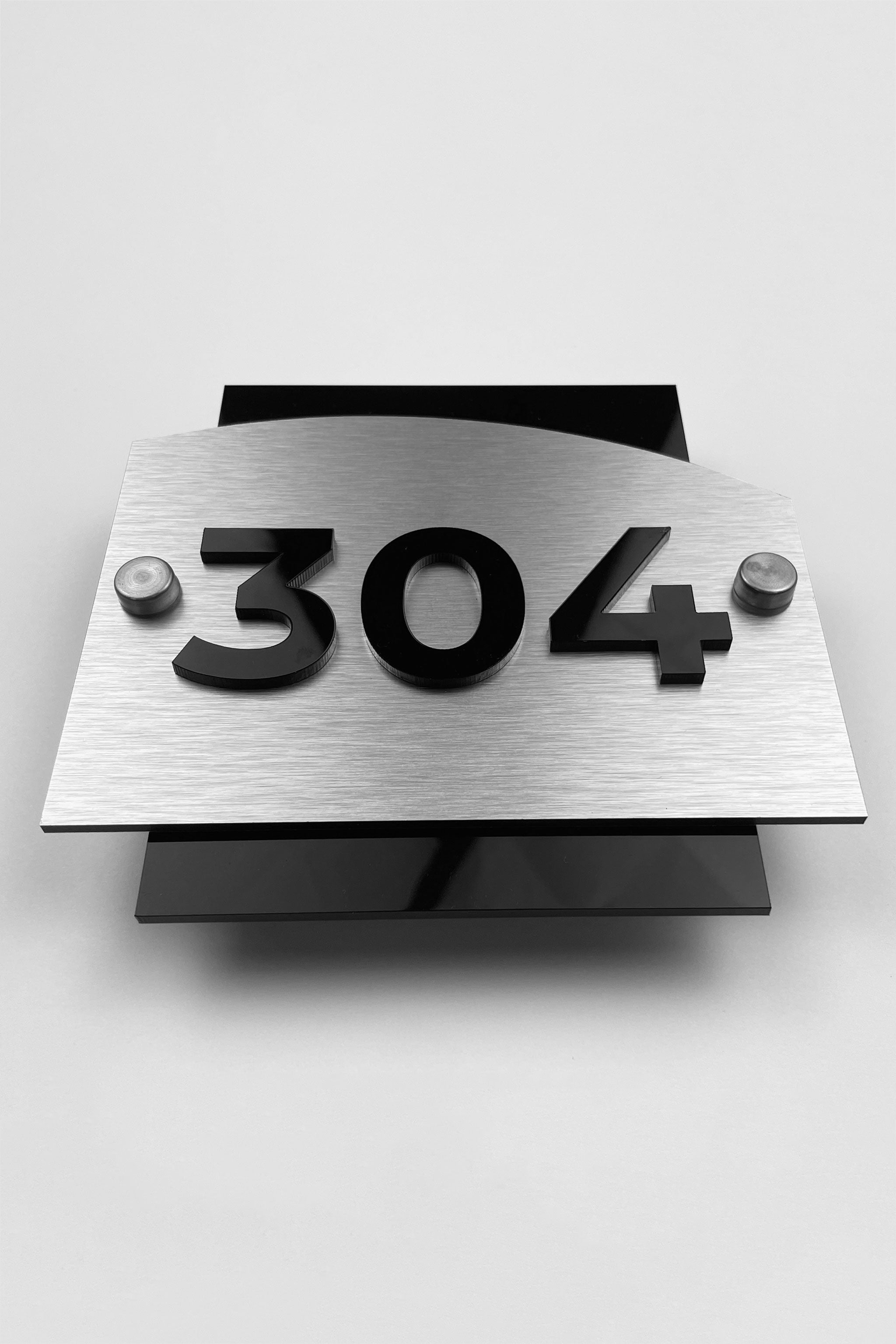 Premium Flow Design hotel room number sign by ALUMADESIGNCO featuring brushed silver metal base and black acrylic 3D numbers, stylish door plaque for hotels