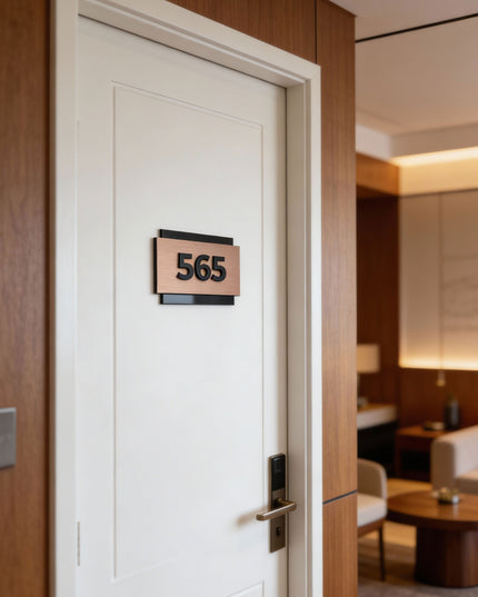 Modern hotel room number sign by ALUMADESIGNCO combining brushed bronze metal panel and 3D acrylic characters, stylish door signage for hospitality interiors
