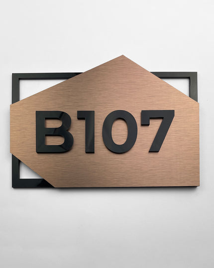 Modern brushed bronze and acrylic glass hotel room number sign by ALUMADESIGNCO, premium door signage for hotel corridors and apartment interiors