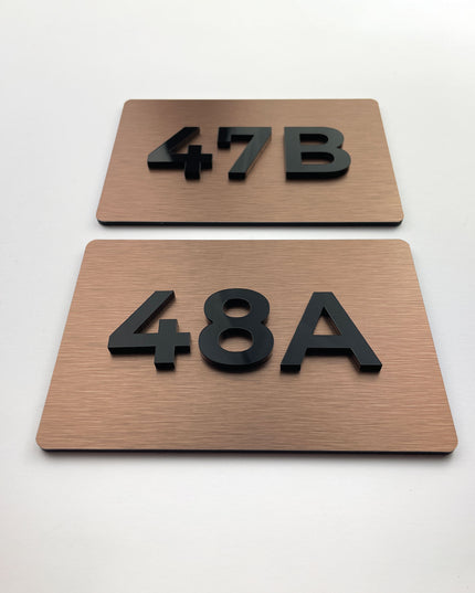 ALUMADESIGNCO brushed bronze door number sign with minimalist modern design, premium signage for boutique hotels and apartment buildings