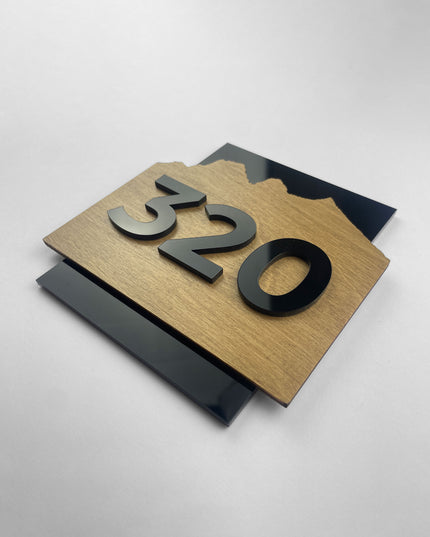ALUMADESIGNCO wood and acrylic door number sign Alpine Design with natural birch plywood background and raised black acrylic characters, premium hotel room signage for modern interiors and hospitality spaces