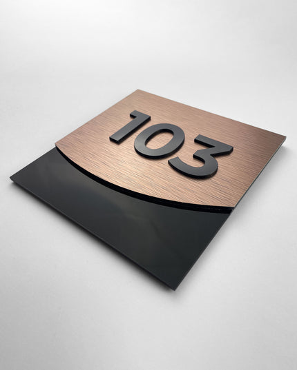 Modern contemporary suite number sign by ALUMADESIGNCO combining bronze metal panel and acrylic glass numbers, stylish door signage for hospitality interiors