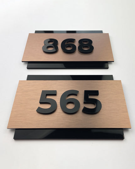 Brushed bronze hotel room number sign with 3D acrylic characters by ALUMADESIGNCO, premium door plaque for hotel corridors and apartment interiors