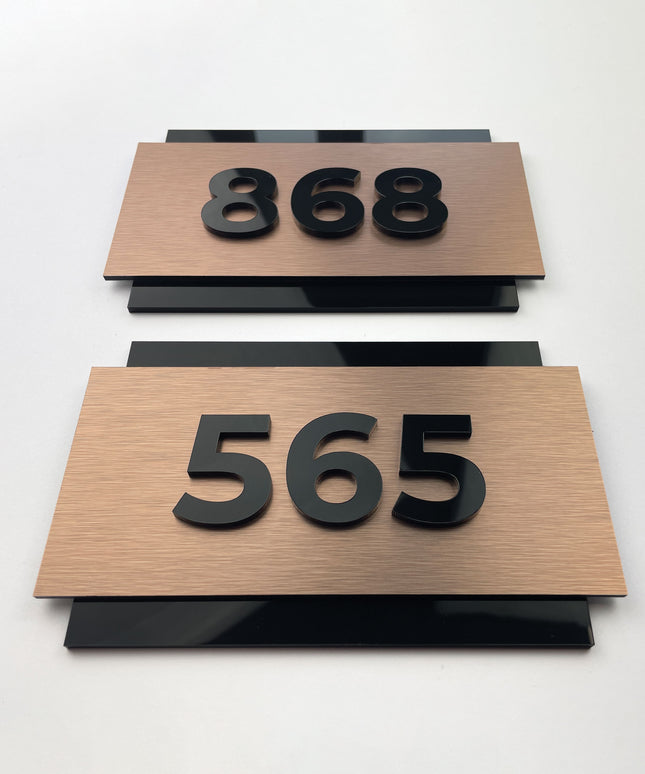 Brushed bronze hotel room number sign with 3D acrylic characters by ALUMADESIGNCO, premium door plaque for hotel corridors and apartment interiors