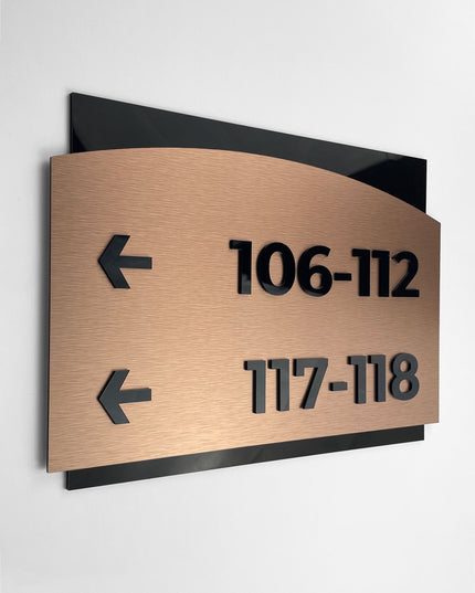 Modern Flow Design interior wayfinding sign by ALUMADESIGNCO combining brushed bronze metal panel and acrylic text, premium directional signage for interior spaces
