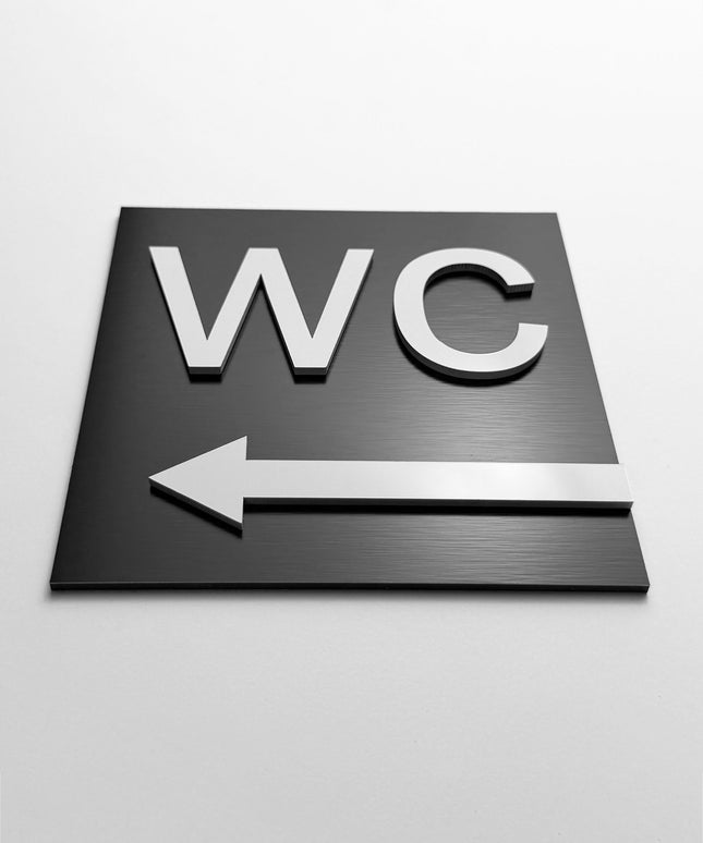 WC arrow left sign by ALUMADESIGNCO, stylish toilet direction plaque for hotels, offices, restaurants, and public interior spaces