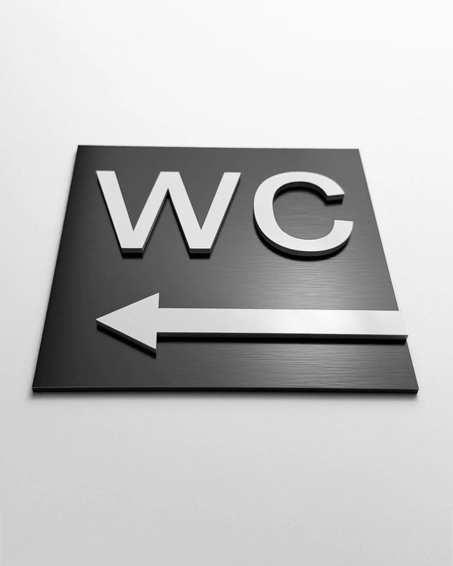 WC arrow left sign by ALUMADESIGNCO, stylish toilet direction plaque for hotels, offices, restaurants, and public interior spaces