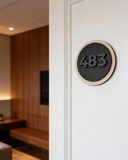 Modern round hotel door number sign by ALUMADESIGNCO featuring natural birch plywood and precision cut black acrylic glass numbers, elegant signage for hotel rooms and apartments