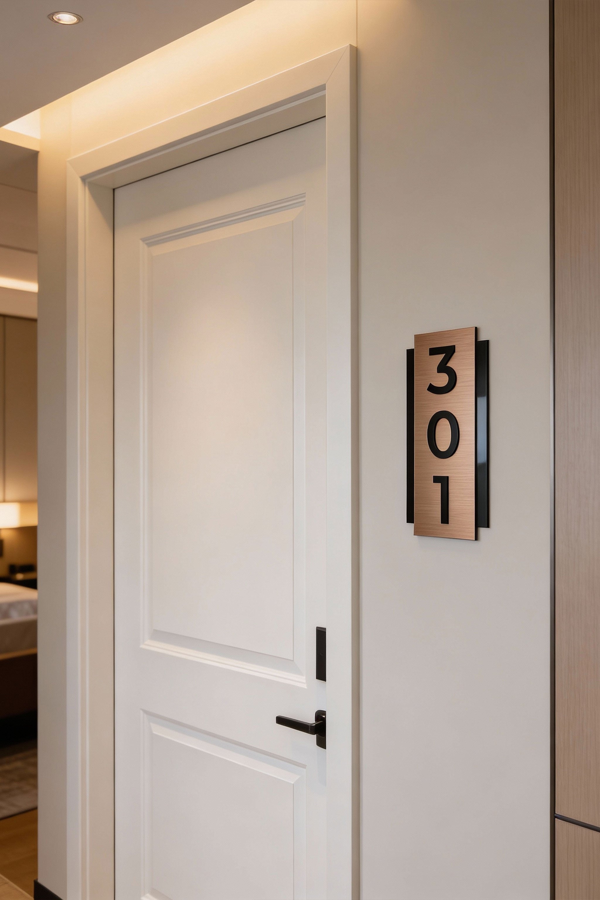 Modern vertical hotel room number sign by ALUMADESIGNCO combining brushed bronze aluminum plaque and black acrylic glass numbers, premium door signage for hospitality interiors