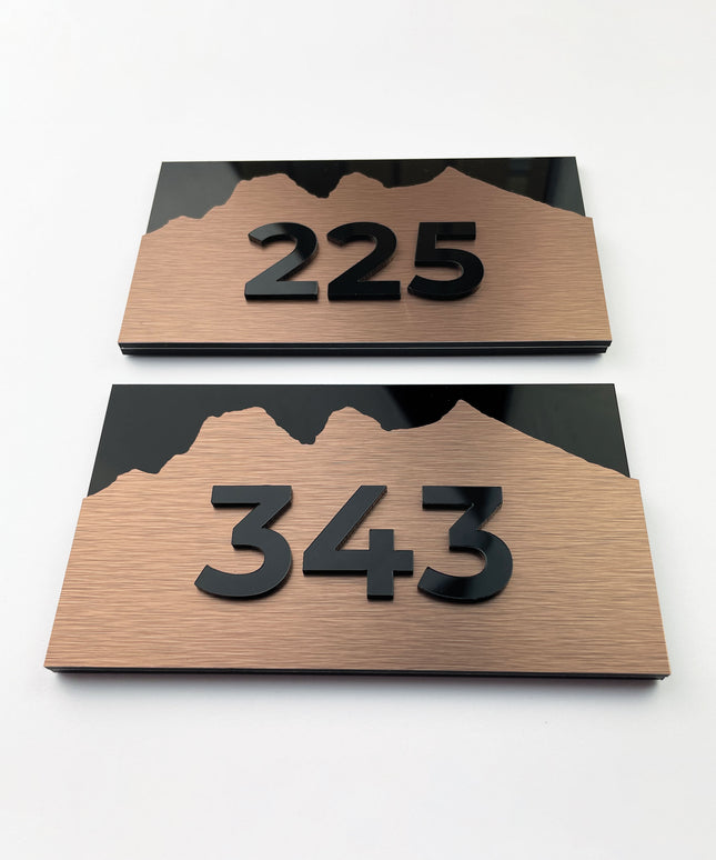Modern Alpine Design high-end room number sign by ALUMADESIGNCO combining brushed bronze metal panel and acrylic numbers, elegant door signage for contemporary interiors
