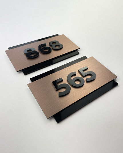 ALUMADESIGNCO brushed bronze room number sign with 3D acrylic characters, premium signage for boutique hotels, apartments, and office spaces