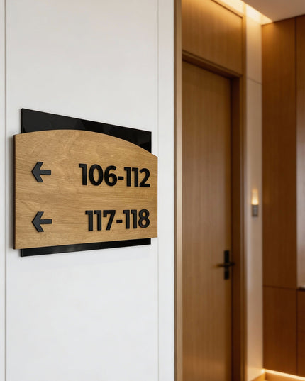 Modern Flow Design arrow wayfinding sign by ALUMADESIGNCO combining birch wood plaque and black acrylic text, premium directional signage for hotels, offices, and contemporary interiors