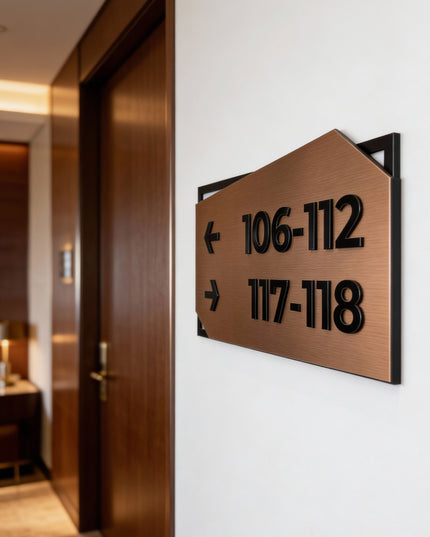 Modern wayfinding wall sign by ALUMADESIGNCO combining brushed bronze metal panel and black acrylic text, stylish directional signage for interior spaces
