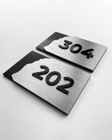 Brushed silver and acrylic hotel room door number sign by ALUMADESIGNCO, modern door signage for hospitality interiors and apartment buildings