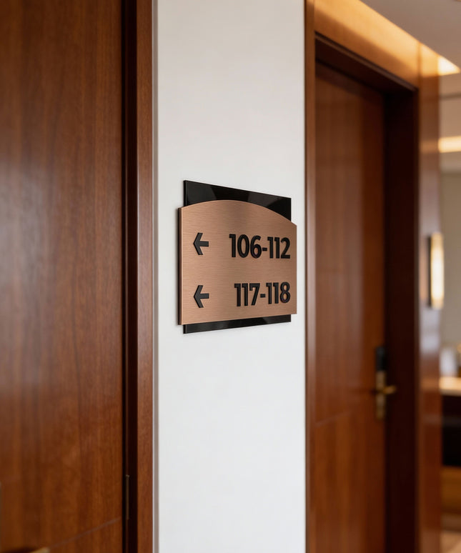 Premium Flow interior directional wall sign by ALUMADESIGNCO featuring brushed bronze plaque and acrylic lettering, modern wayfinding signage for hospitality and office interiors