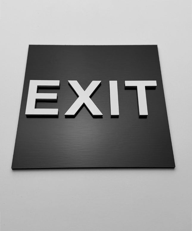 Emergency exit sign by ALUMADESIGNCO, clear directional safety plaque for corridors, offices, hotels, and public interior spaces