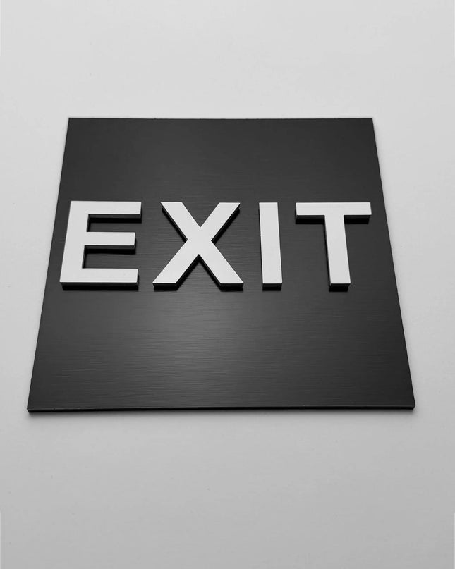 Emergency exit sign by ALUMADESIGNCO, clear directional safety plaque for corridors, offices, hotels, and public interior spaces
