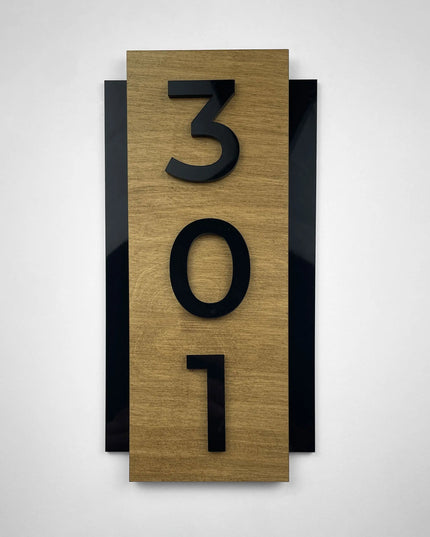 Vertikales Hotelschild von ALUMADESIGNCO mit natürlicher Holzoberfläche und einer individuell angefertigten Zimmernummer aus schwarzem Acryl.